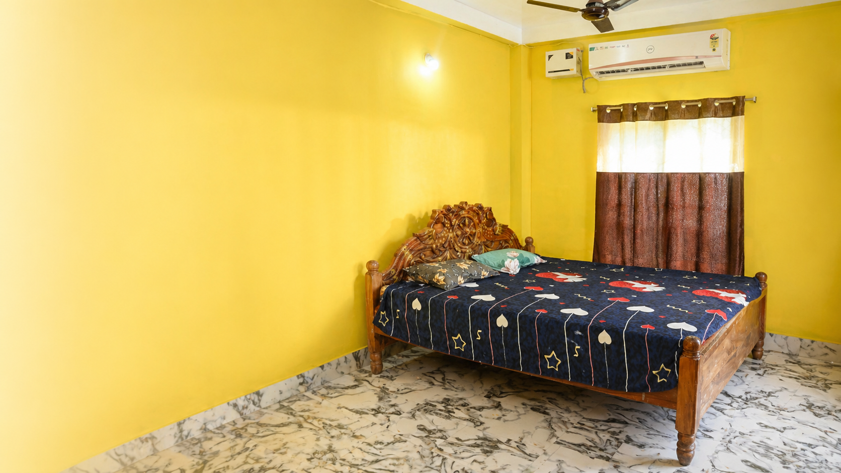 Sunnyasort yellow guest room prepared for a stay, with wooden bed, AC, curtain, and marble-pattern floor